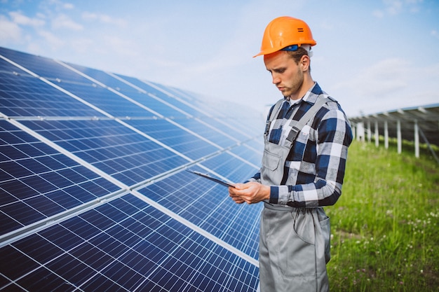 Homem trabalhador no firld pelos painéis solares