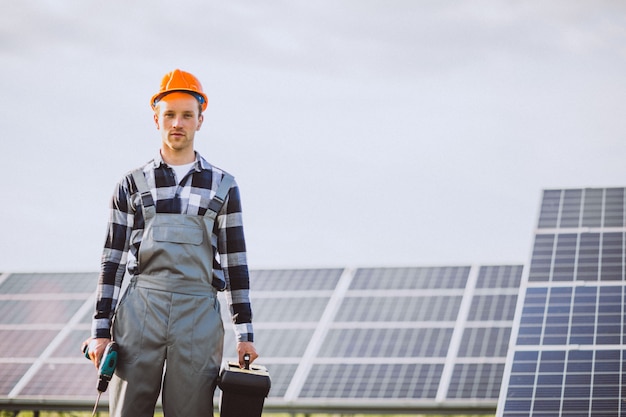 Homem trabalhador no firld pelos painéis solares