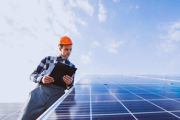 Homem trabalhador no firld pelos painéis solares