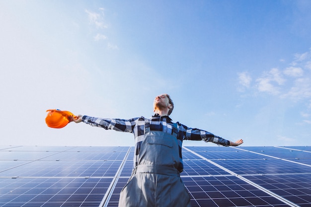 Homem trabalhador no firld pelos painéis solares