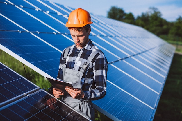 Homem trabalhador no firld pelos painéis solares