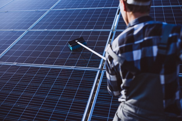 Homem trabalhador no firld pelos painéis solares