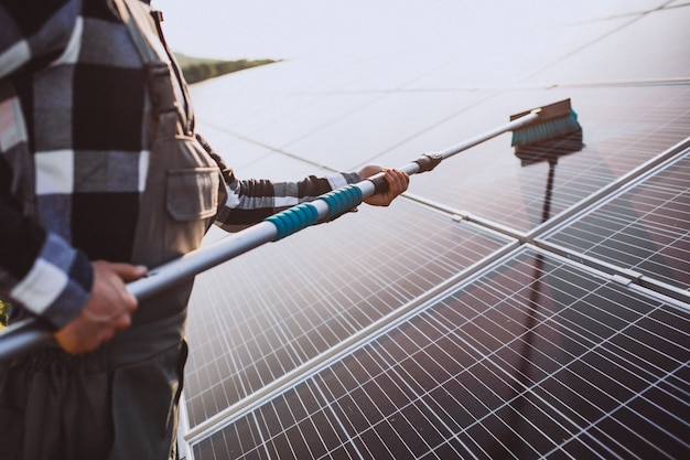 Homem trabalhador no firld pelos painéis solares