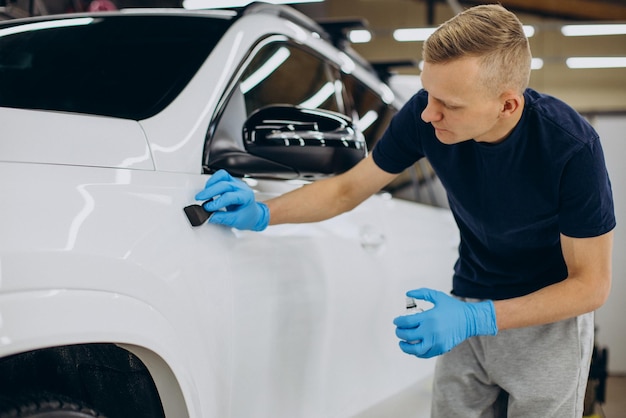 Homem trabalhando carro detalhando e carro de revestimento