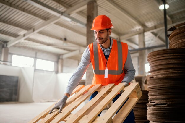 Homem trabalhando com materiais pesados de madeira