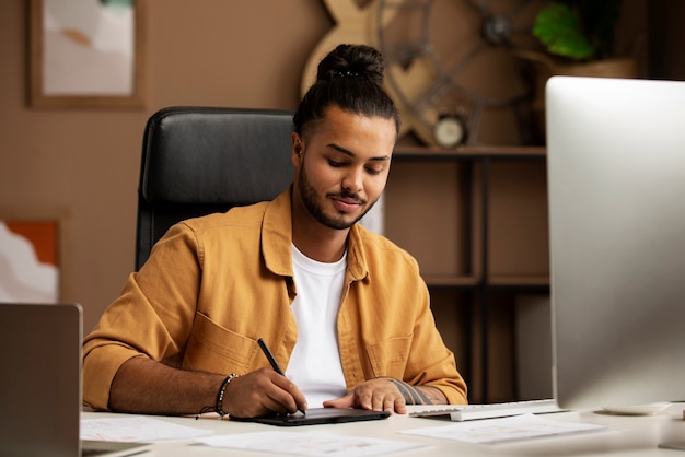 Homem trabalhando com vista frontal de dispositivos