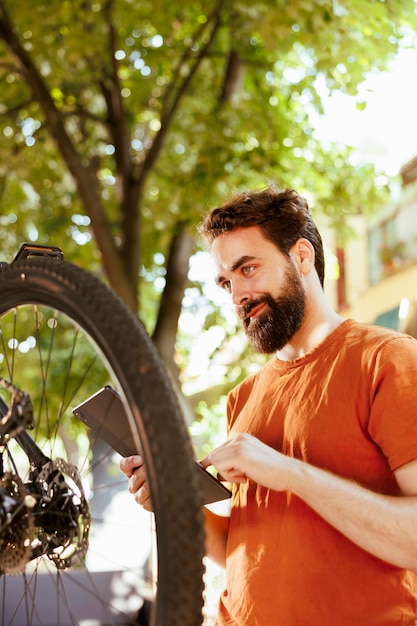 Foto grátis homem trabalhando em bicicleta com tablet inteligente