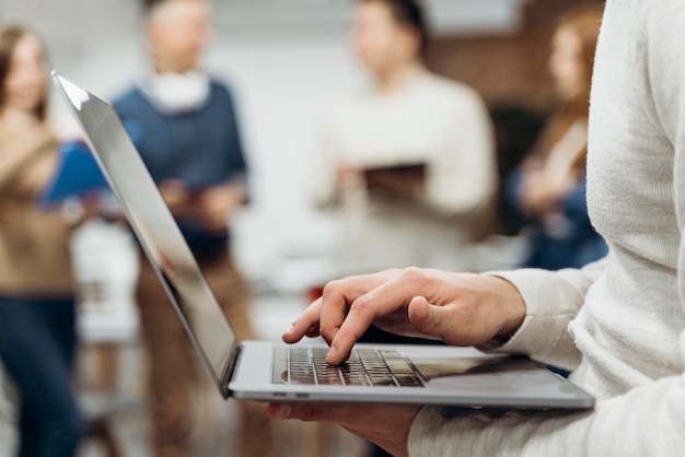 Homem trabalhando em um laptop em pé