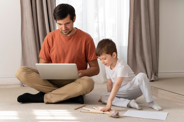 Homem trabalhando no chão com filho tiro completo