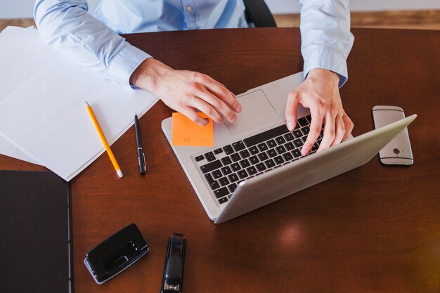 Homem trabalhando no laptop sentado na mesa