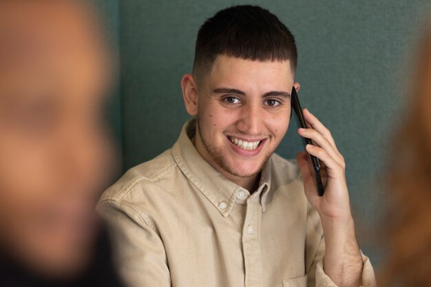 Homem trans no trabalho usando seu smartphone
