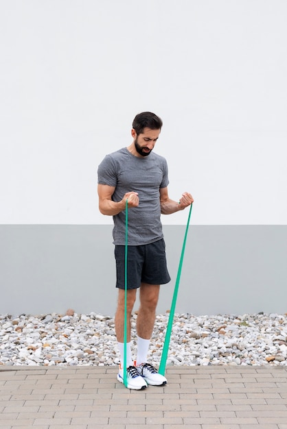 Foto grátis homem treinando com elástico tiro completo