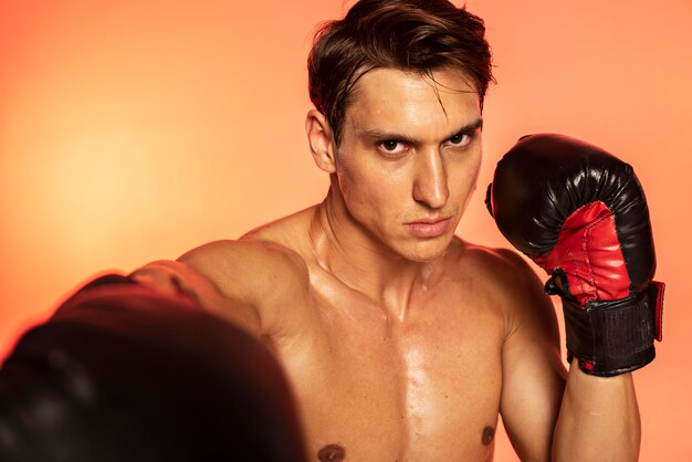 Homem treinando com luvas de boxe de perto
