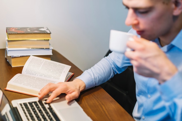 Foto grátis homem turva bebendo e usando o laptop