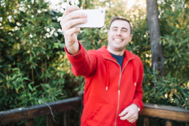 Homem turva tomando selfie no parque