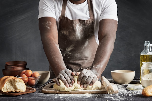 Homem usando avental assando na cozinha