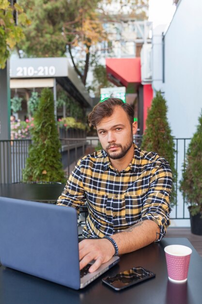 Homem, usando computador portátil, em, loja café