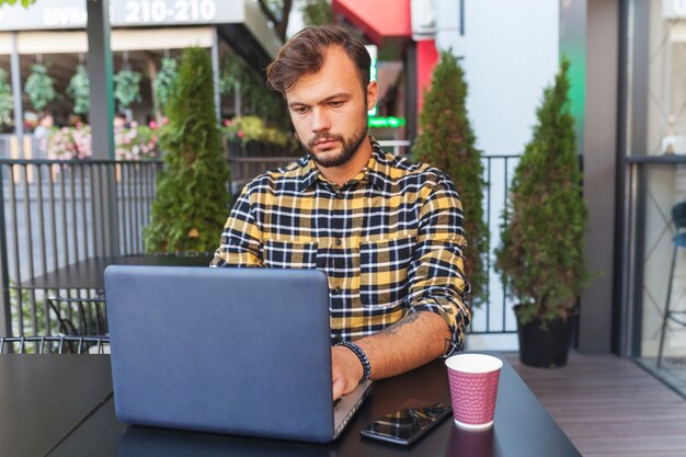 Homem, usando computador portátil, em, loja café