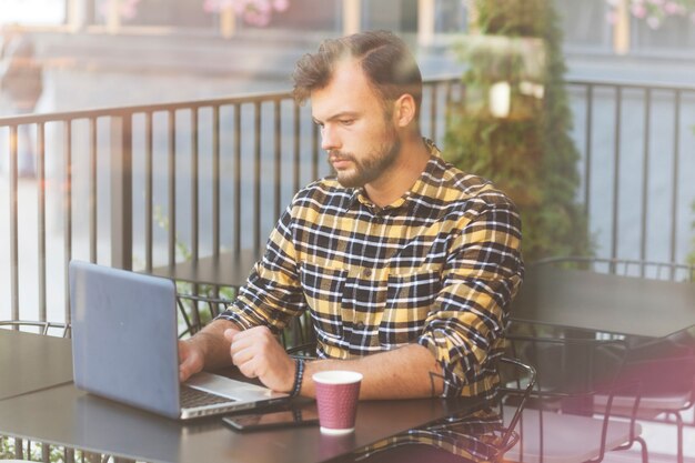 Homem, usando computador portátil, em, loja café