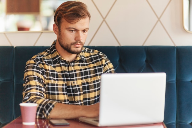 Homem, usando computador portátil, em, loja café