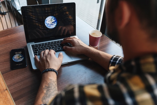 Homem, usando computador portátil, em, loja café