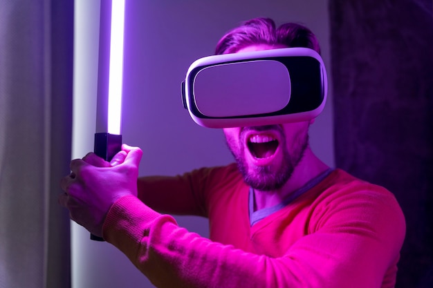 Homem usando fone de ouvido de realidade virtual e brincando com espada de laser