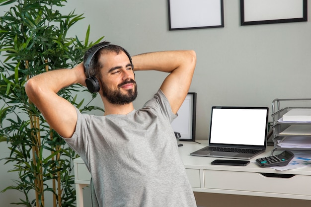 Homem usando fones de ouvido enquanto trabalha em casa