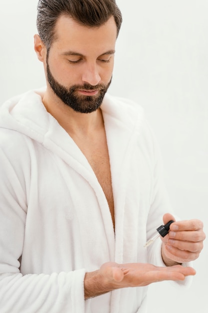 Foto grátis homem usando óleos naturais no rosto