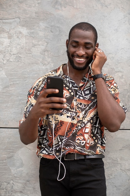 Foto grátis homem usando smartphone moderno com fones de ouvido