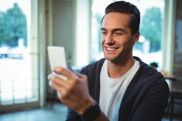 Homem usando telefone celular no café