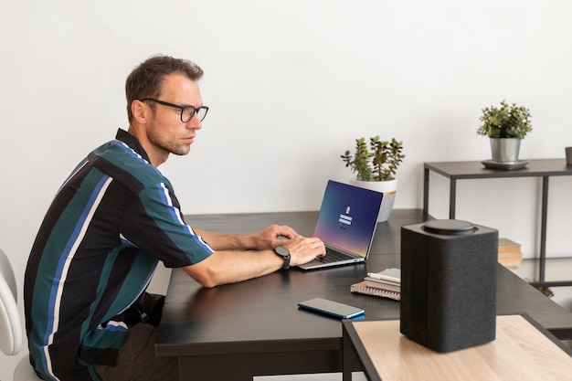 Homem usando um alto-falante inteligente enquanto trabalha