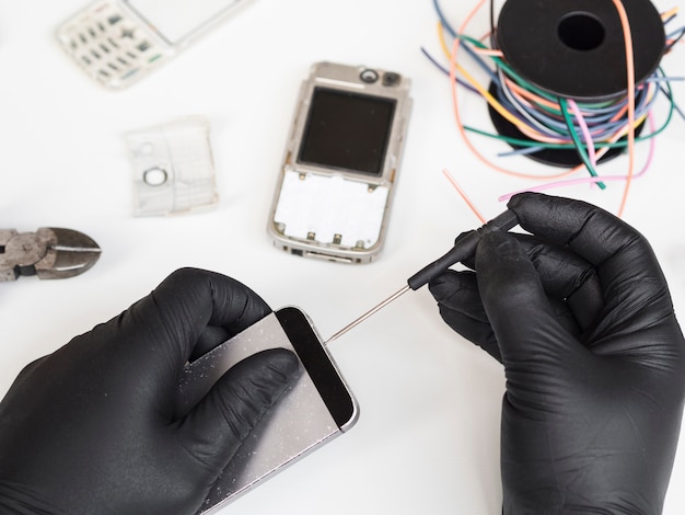 Homem usando uma chave de fenda para abrir um telefone