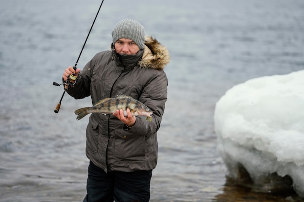 Foto grátis homem usando uma vara de pescar para pegar peixes