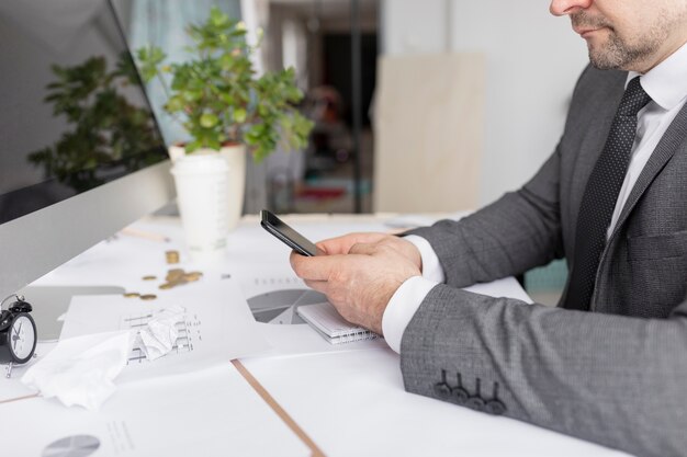 Homem verificando seu telefone no trabalho