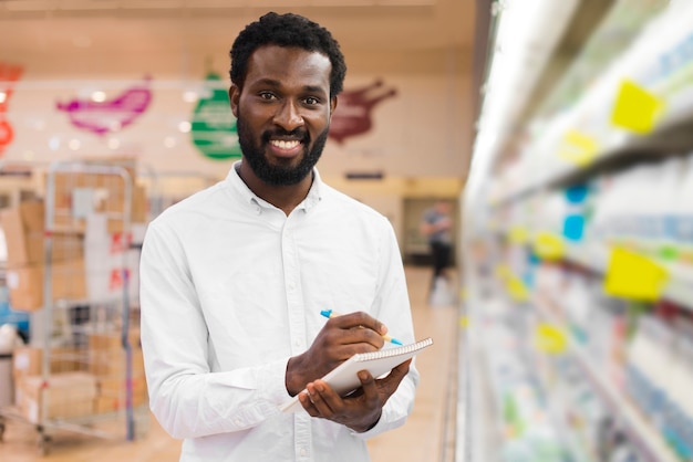 Foto grátis homem, verificar, itens, em, lista fazendo compras