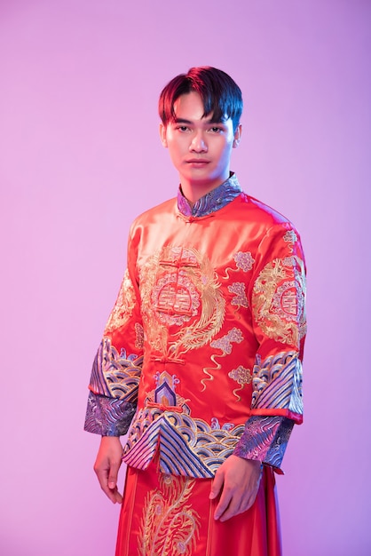 Homem veste Cheongsam para dar as boas-vindas ao viajante que compra no ano novo chinês