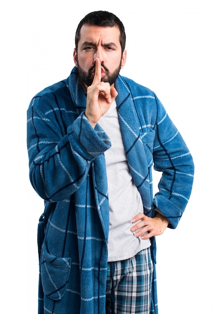 Homem vestido de baile fazendo gesto de silêncio