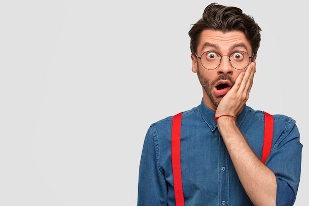 Homem vestindo camisa jeans e suspensórios vermelhos