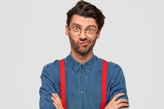 Homem vestindo camisa jeans e suspensórios vermelhos