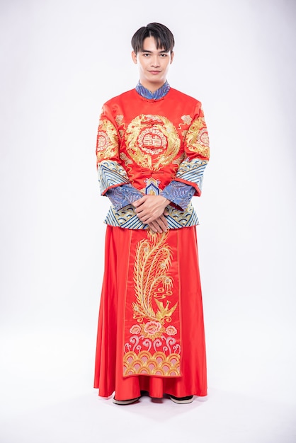 Foto grátis homem vestindo cheongsam sorrindo para dar as boas-vindas ao viajante que faz compras no ano novo chinês