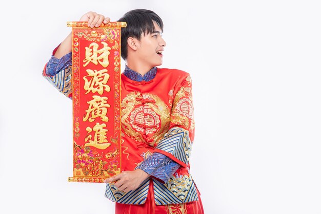 Homem vestindo terno Cheongsam dá à família o cartão chinês para dar sorte no ano novo chinês
