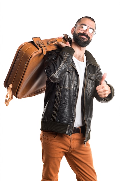 Homem vestindo uma jaqueta de couro segurando uma mala