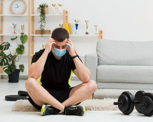 Homem vestindo uma máscara médica enquanto vestindo roupas esportivas