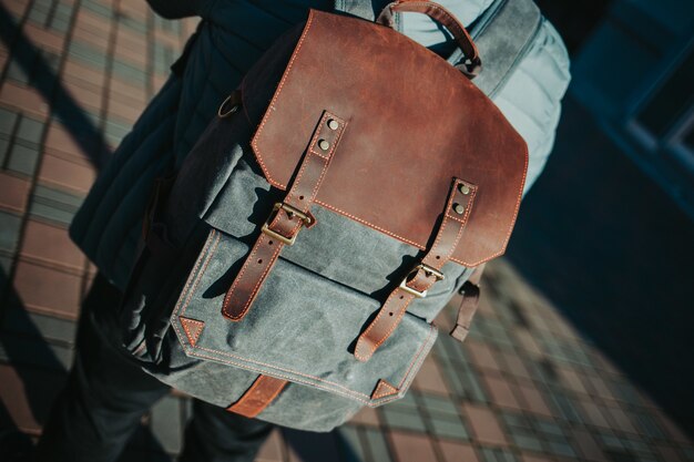 Homem vestindo uma mochila cinza e marrom