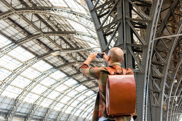 Homem viaja com mochila, tirando fotos