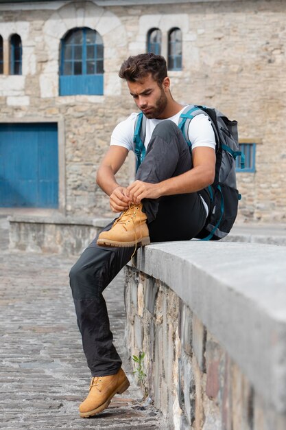 Homem viajando sozinho em mutriku, tendo seus fundamentos em uma mochila