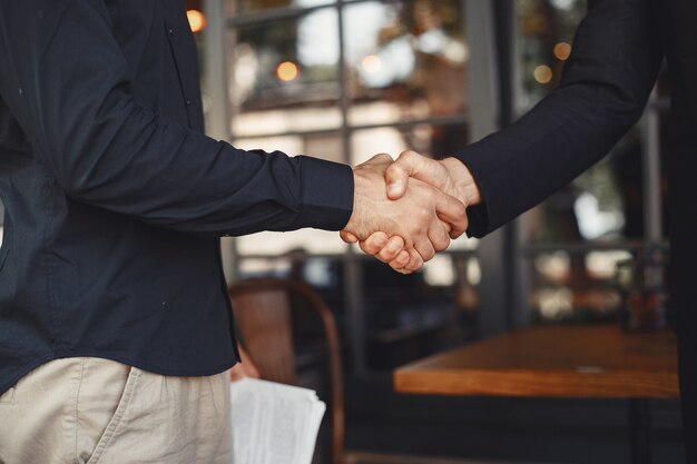 Homens apertam as mãos. Anexo de um acordo comercial. Entendimento entre parceiros de negócios.
