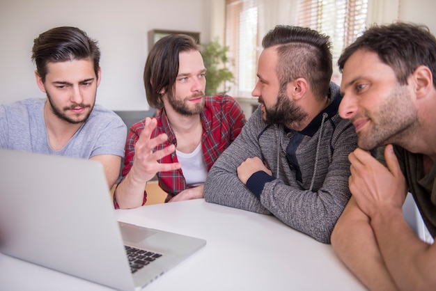 Homens assistindo a um vídeo em um laptop