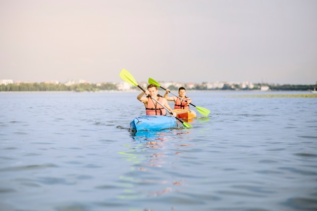 Homens caiaque no lago