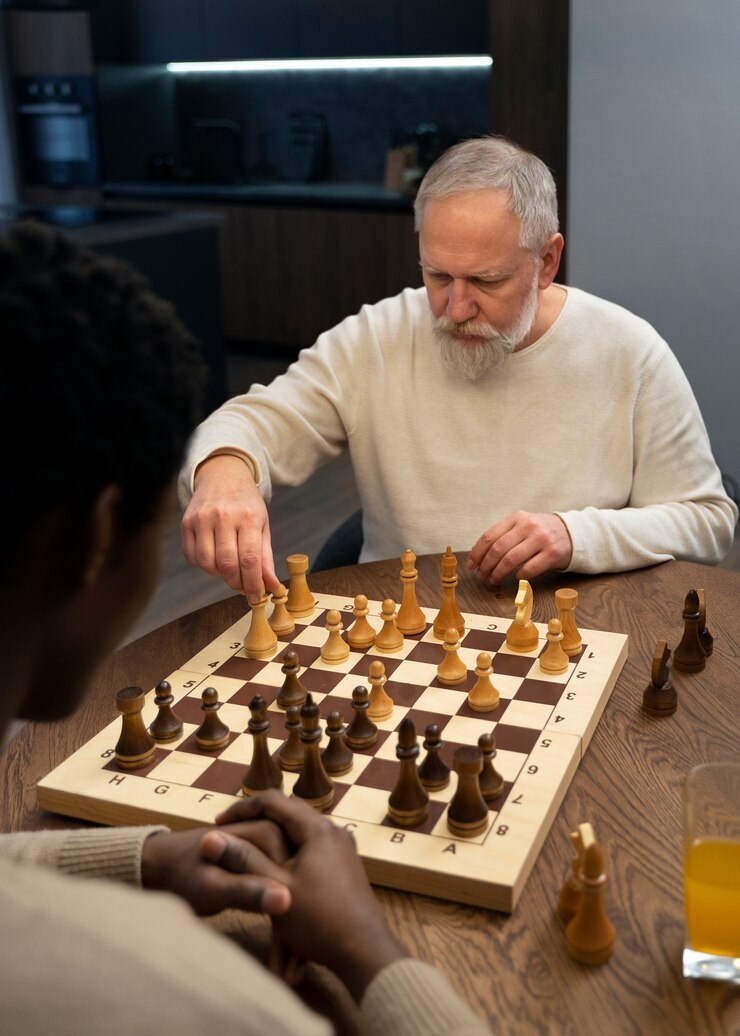 Foto grátis homens de alto ângulo jogando xadrez dentro de casa
